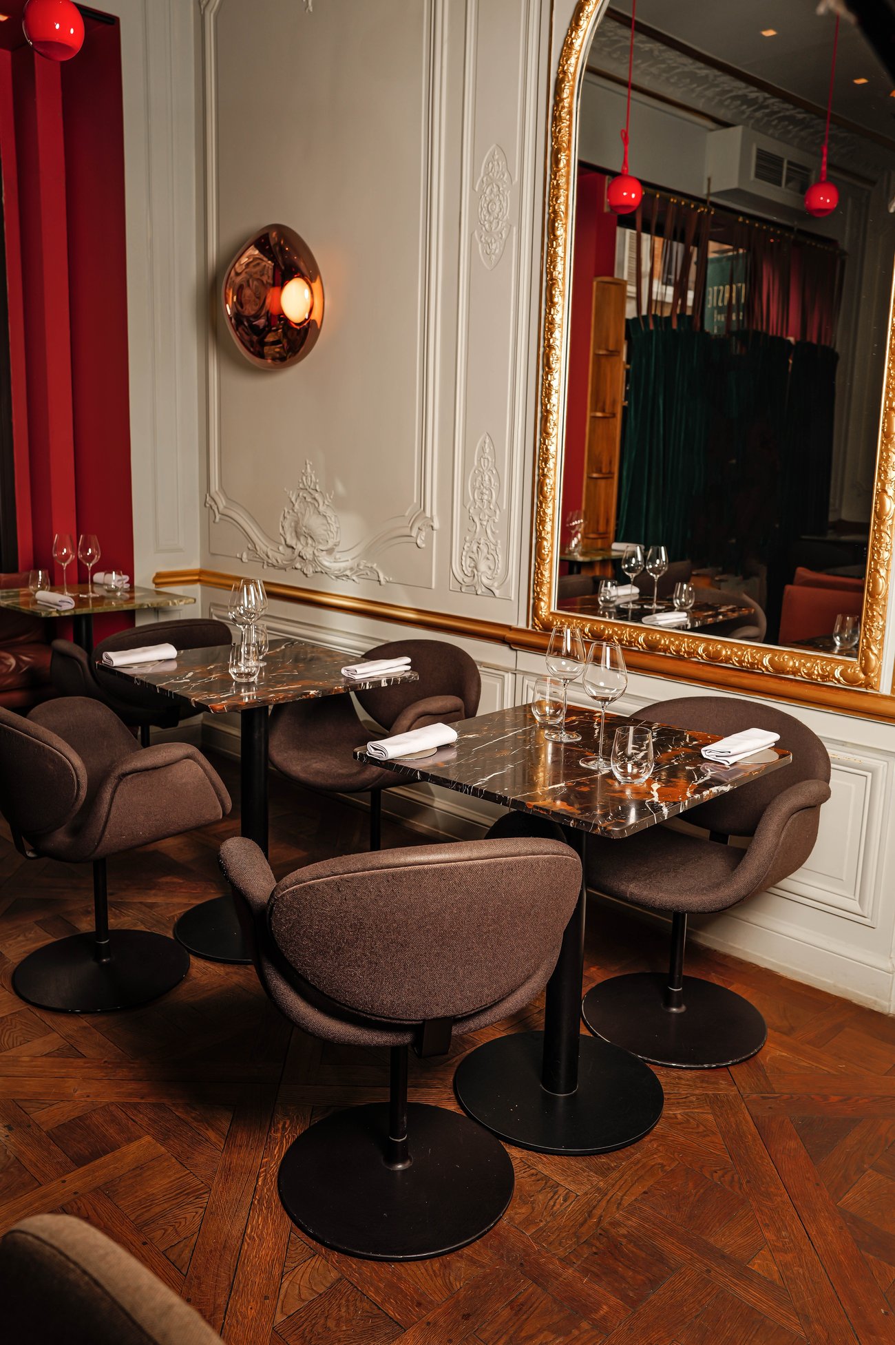 La salle de Contraste, miroir doré, suspensions rouges et parquet à bâtons rompus, Paris 8ᵉ